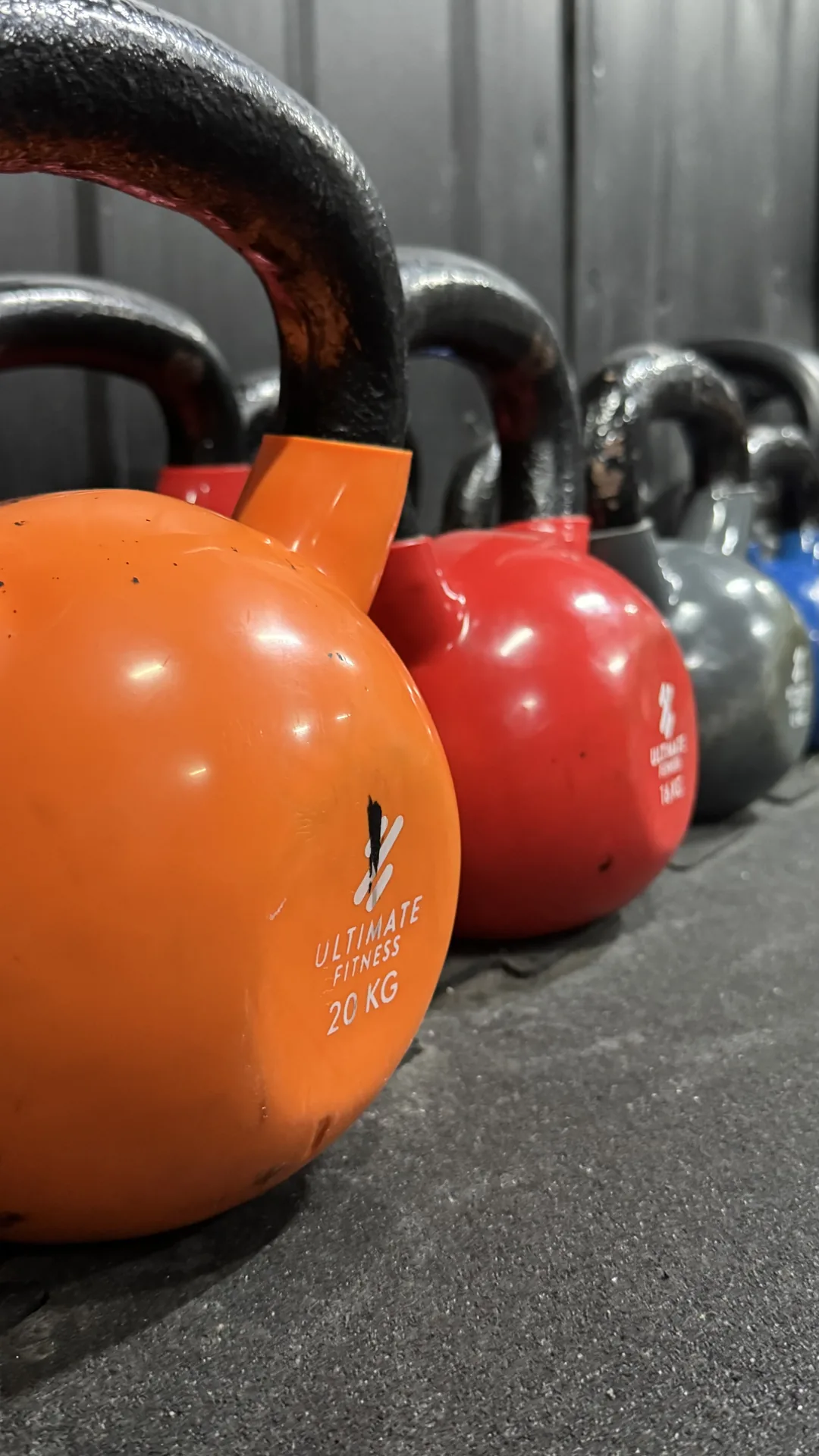 Fila de kettlebells de colores para entrenamiento funcional